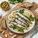 Fresh boquerones marinated in olive oil, lemon, and garlic served as tapas with olives, nuts, and bread.