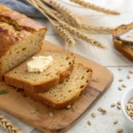 Golden-brown wheatberry bread with melted butter and visible wheatberries